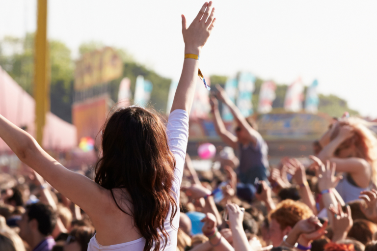 Event "Summerty Festival" Menschenmenge feiert auf einem Festival, Hände sind in die Luft gestreckt.