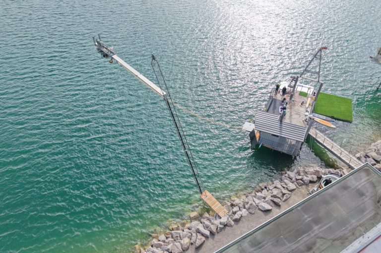 Seifenkistenrennen Ein Steg am Wasser mit Kränen und Personen bei der Arbeit.