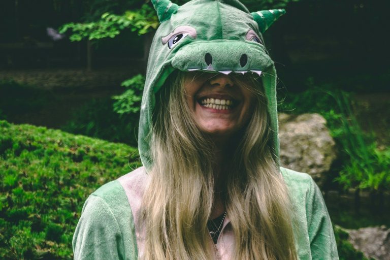 Kostümwettbewerb Person in einem grünen Drachenkostüm mit langen, blonden Haaren und lächelndem Gesicht.